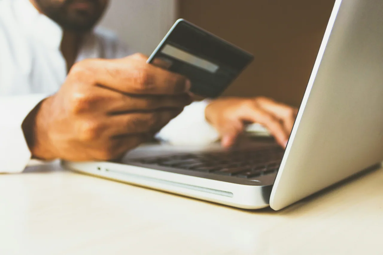 Person entering payment details on a laptop, reviewing costs